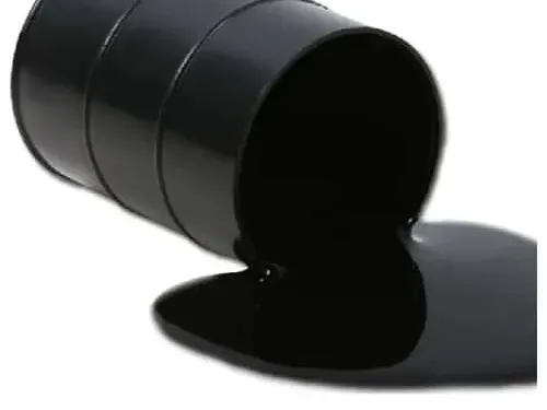 Black bitumen spilling from a tipped drum